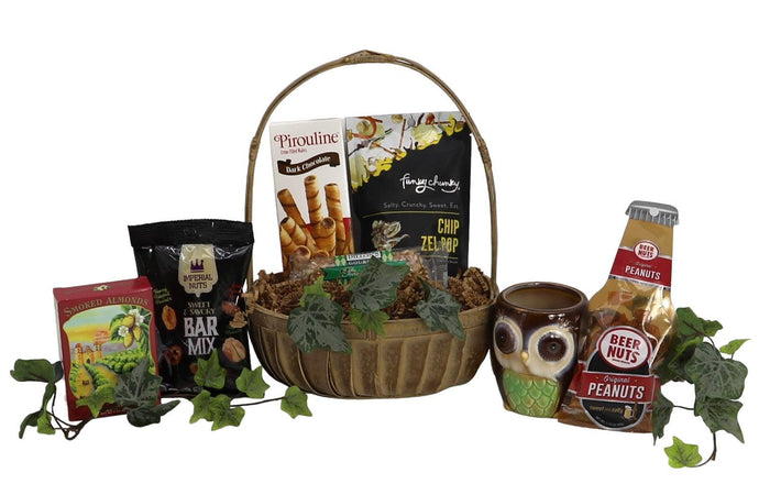 Themed gift basket with snacks, chocolate, and a ceramic mug in a woven handle basket