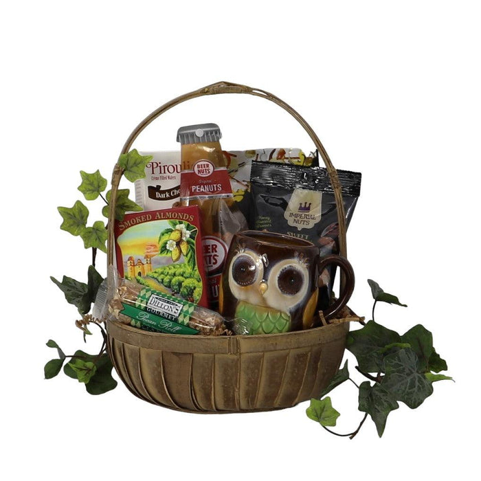 Themed gift basket with assorted snacks, nuts, and an owl mug in a woven handle basket