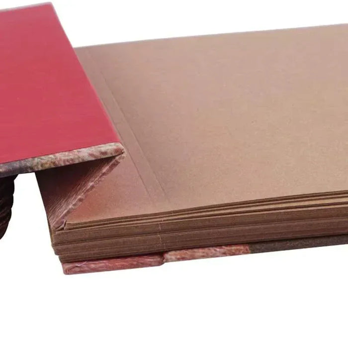 Stacked adventure scrapbook albums showing thick pages and stitched edges.