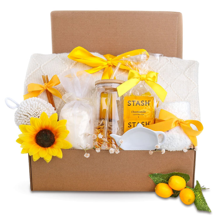 Gift box with yellow ribbons, STASH chamomile jars, white towel, and sunflowers