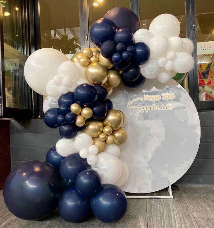 Navy, white, and gold balloon garland cluster with large gold accent balloons