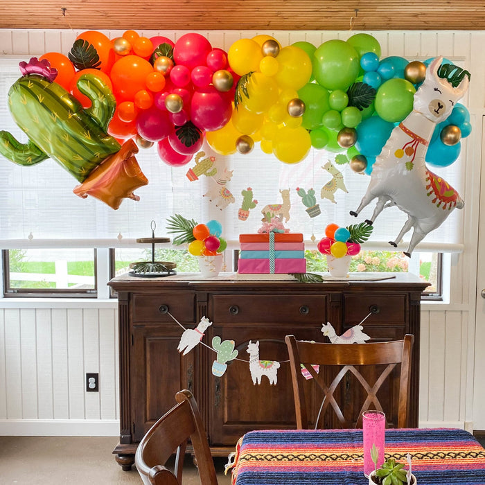 Neon tropical balloon garland arch with alpaca and cactus foil balloons over console