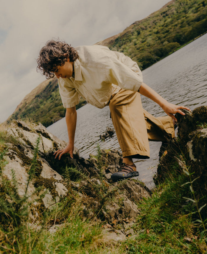 Keen Newport Leather sandals in brown with secure toe protection and durable straps, worn outdoors near a lake.