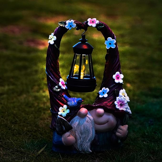 Garden gnome couple decoration with blue bird and glowing solar lantern inside floral wreath
