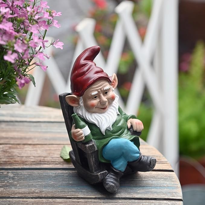 Garden gnome drinking wine statue sitting on dark chair, red hat and blue pants