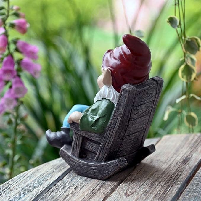 Back view wine gnome statue on dark chair, red hat, white beard, holding bottle