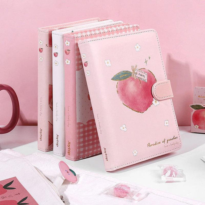 Peach-themed notebook set with pink and white covers, ribbon bookmarks, and peach graphics