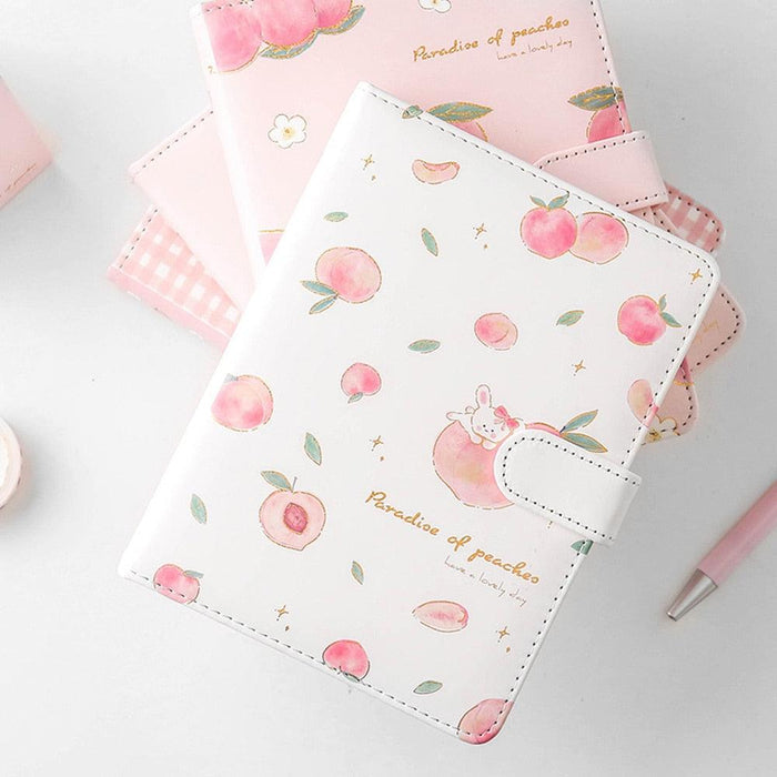 Pink and white peach notebook with cute rabbit graphic, side strap, and stitched border