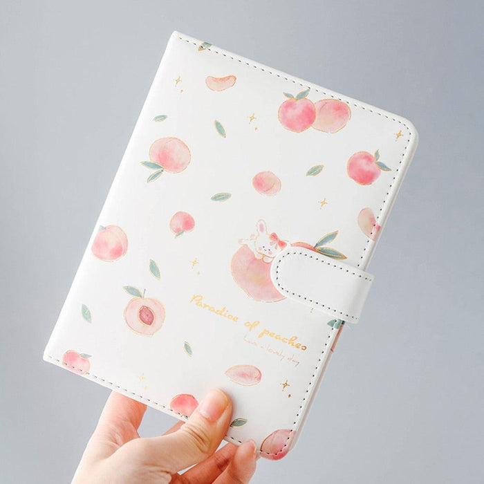 Peach-themed notebook with fruit pattern, side strap, stitched corners, and a small bunny graphic