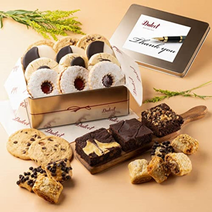 Gold gift tin of assorted cookies and brownies, lid open with “Thank you” card