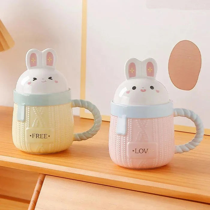 Bunny ceramic mug set with pink and blue bodies, rabbit lids, and 'LOVE'/'FREE' text.
