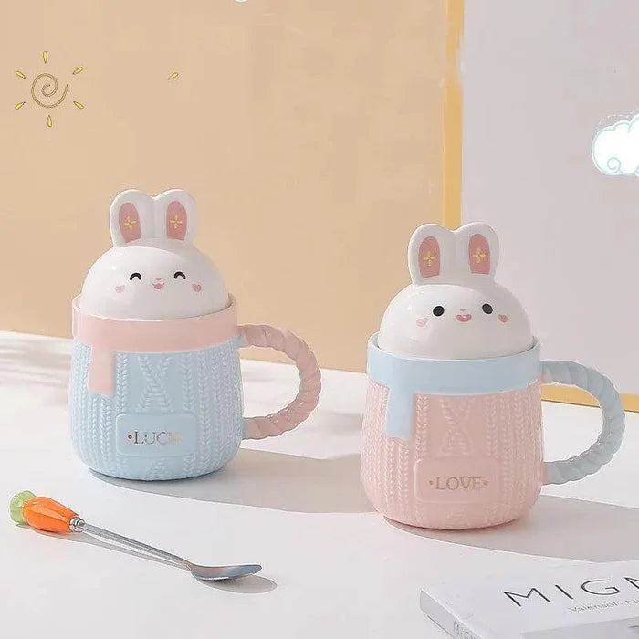 Bunny ceramic mug pair with blue and pink bodies, rabbit lids, and 'LUCK'/'LOVE' text.