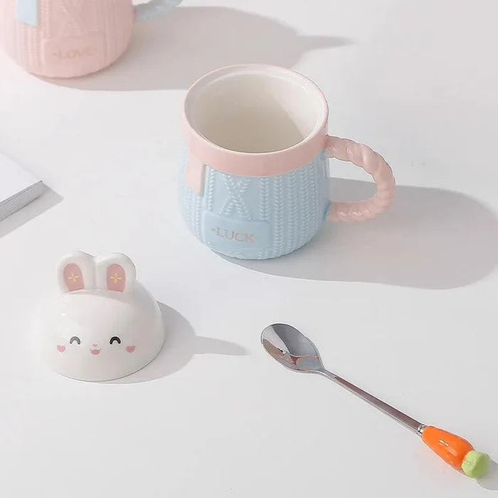Blue bunny ceramic mug with rabbit lid, textured body, and 'LUCK' text.