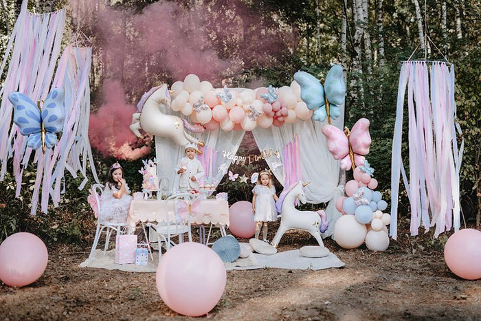 Pastel balloon decor with butterfly balloon centerpiece and pink, white, and blue balloon clusters