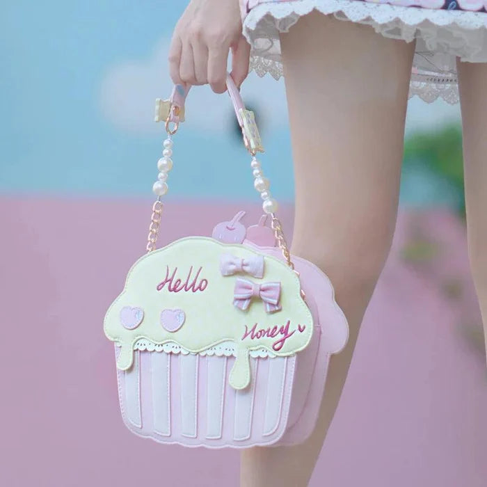 Cupcake-shaped bag with mint top, pink striped sides, pearl handle and bow detail