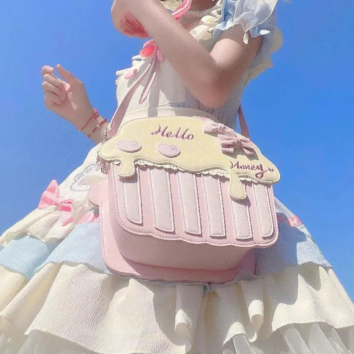 Cupcake-shaped bag with pale pink bottom and cream top, 'Hello' script and bow