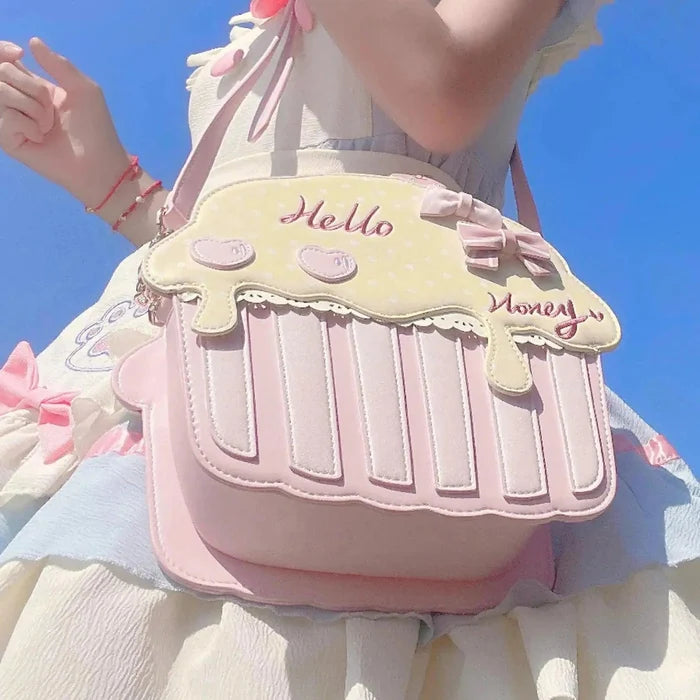 Cupcake-shaped bag with pale yellow top, pink striped base, 'Hello' and 'Money' accents