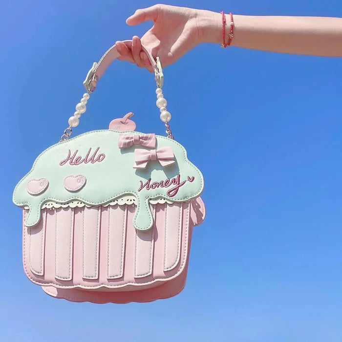 Cupcake-shaped bag with mint top, pink bow, pearl handle, and 'Hello' script