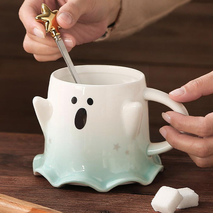 Ghost face mug being stirred with a gold star-topped spoon; pale green base visible
