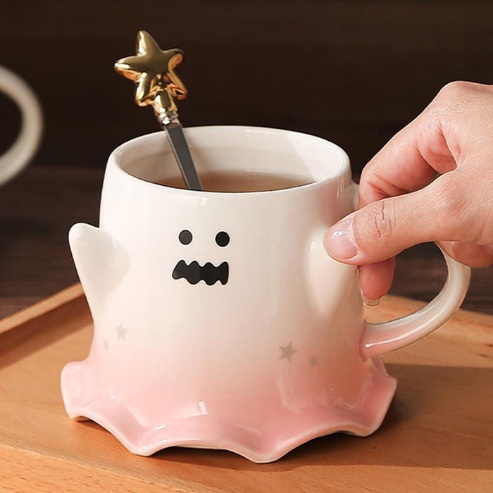 Ghost face mug with wavy mouth and gold star stirrer; pastel pink base and side handle