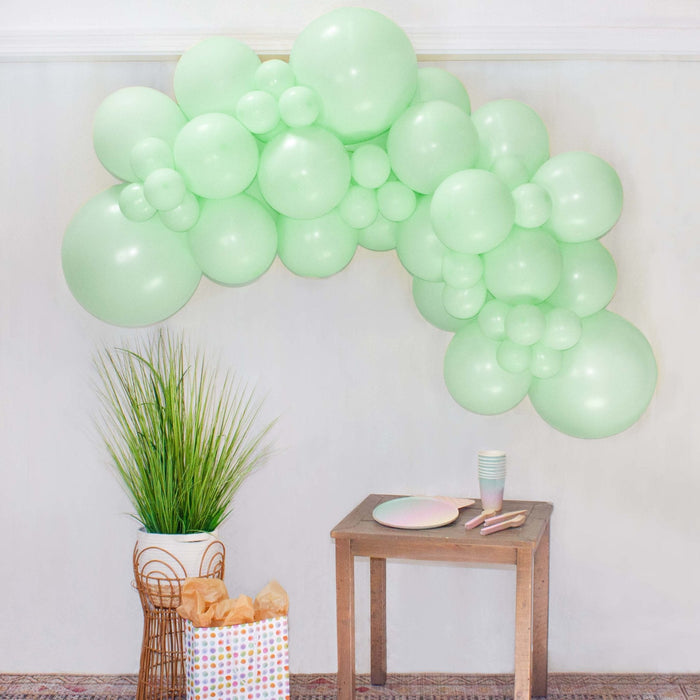 Balloon garland with pastel green round balloons arranged in an arch