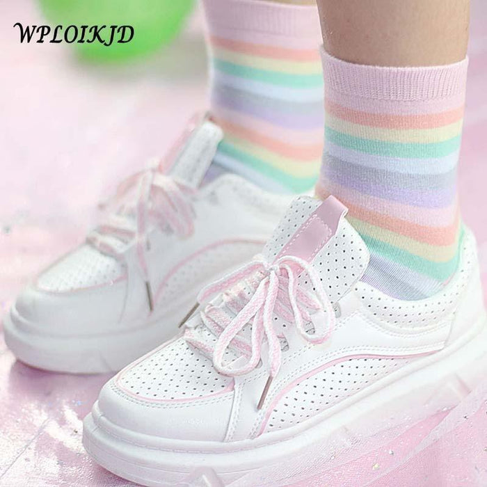 Pastel rainbow striped socks with ribbed cuffs on a leg