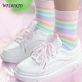 Pastel rainbow striped socks with ribbed cuffs on a leg