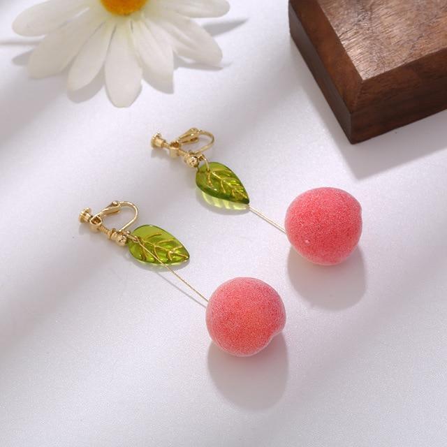 Dangling leaf earrings with pink pom-poms and green charms
