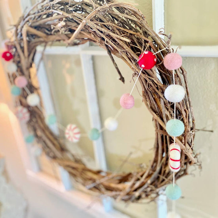 Peppermint felt ball garland wreath close-up with dangling felt balls in pink, mint and red