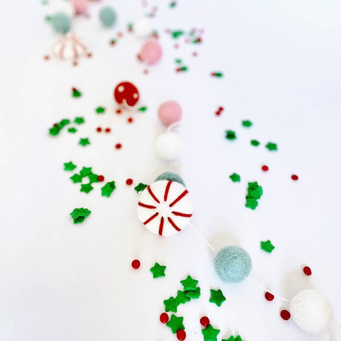 Peppermint felt ball garland close-up with peppermint-pattern felt round and pastel felt balls