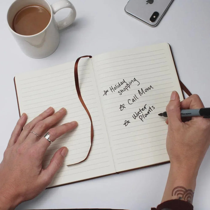 Open notebook with lined pages; hand writing with pen and holiday notes