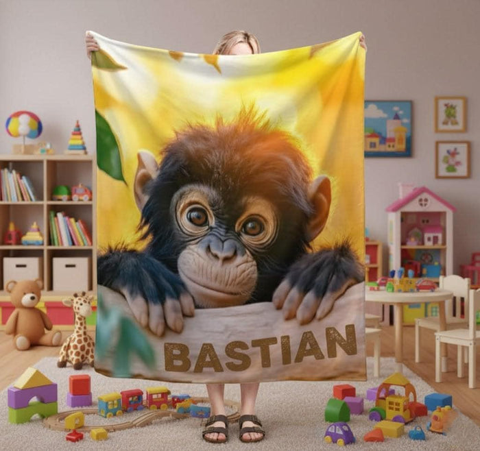 Personalized baby chimpanzee blanket showing a chimp face and name 'BASTIAN' in front