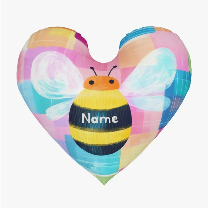 Heart-shaped plush pillow close-up with bee face, pastel wings, and custom name patch
