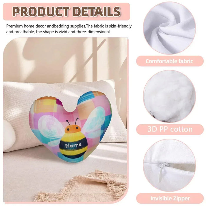 Heart-shaped plush pillow with bee design and custom name patch on a sofa pillow