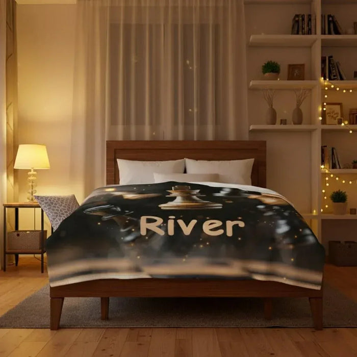 Personalized chess blanket on bed with River text, dark design with gold chess pieces