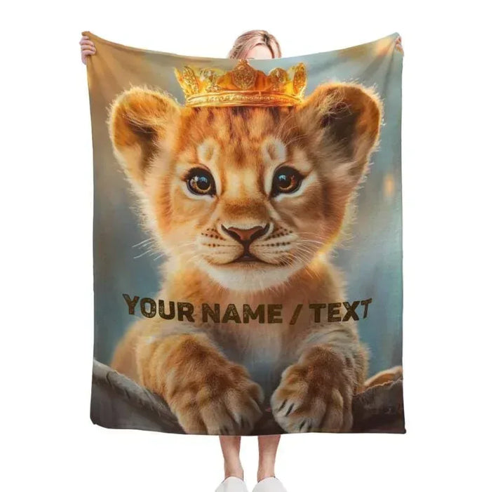 Lion cub baby blanket with gold crown and 'YOUR NAME / TEXT' personalized print.