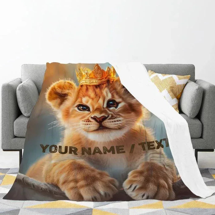 Lion cub throw blanket with gold crown and 'YOUR NAME / TEXT' across the center.