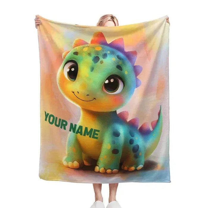 Rainbow dinosaur fleece blanket with smiling green dragon graphic and YOUR NAME text