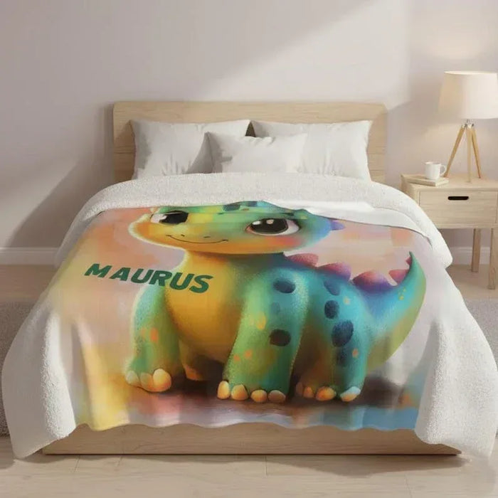 Rainbow dinosaur fleece blanket with smiling green dragon graphic and MAURIS text