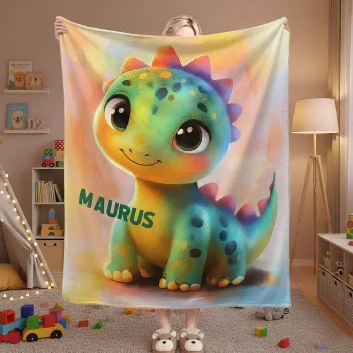 Rainbow dinosaur fleece blanket with smiling green dragon graphic and MAURUS text