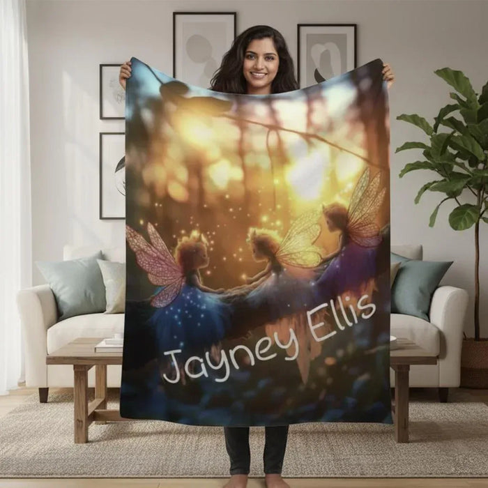 Personalized fairy throw blanket held in front of sofa, winged fairies and name text
