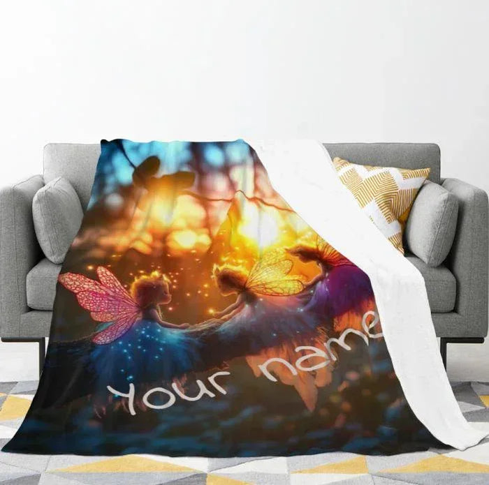 Personalized fairy throw blanket draped on sofa, winged fairies and cursive name text