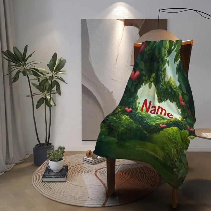 Custom name garden heart throw blanket draped over a chair, green leaves and hearts