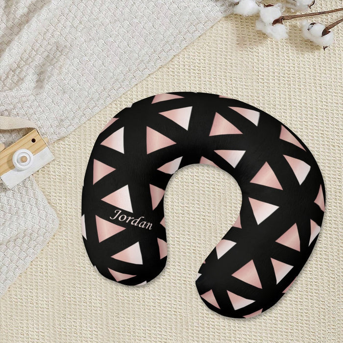 U-shaped travel neck pillow on bed, black with pink triangle pattern, Jordan