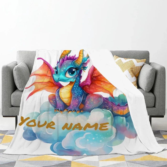Personalized dragon fleece blanket on gray sofa with unicorn dragon and Your Name