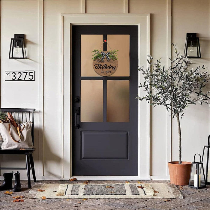 Wooden round Happy Birthday sign with greenery and black plaid bow on front door