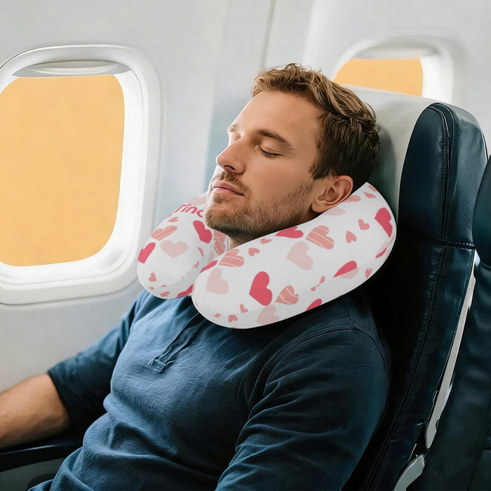 U-shaped travel neck pillow with pink hearts pattern worn around the neck