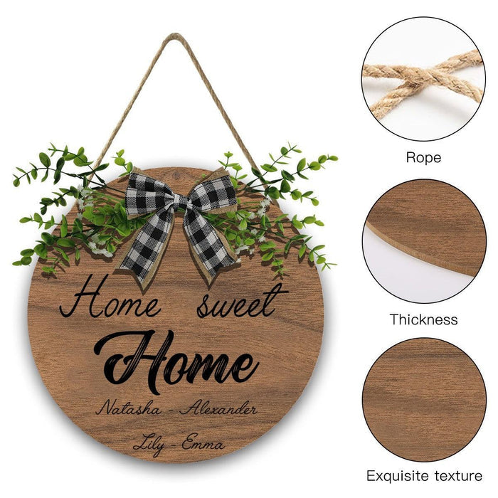 Round wooden hanging sign with rope loop, plaid bow, and green leafy accents
