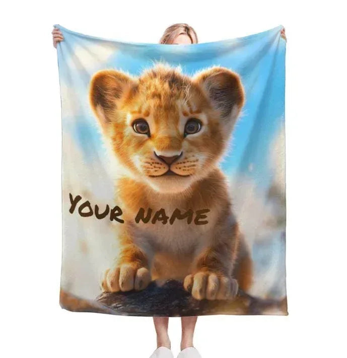 Personalized lion cub baby blanket, blue background, 'YOUR NAME' printed in dark text