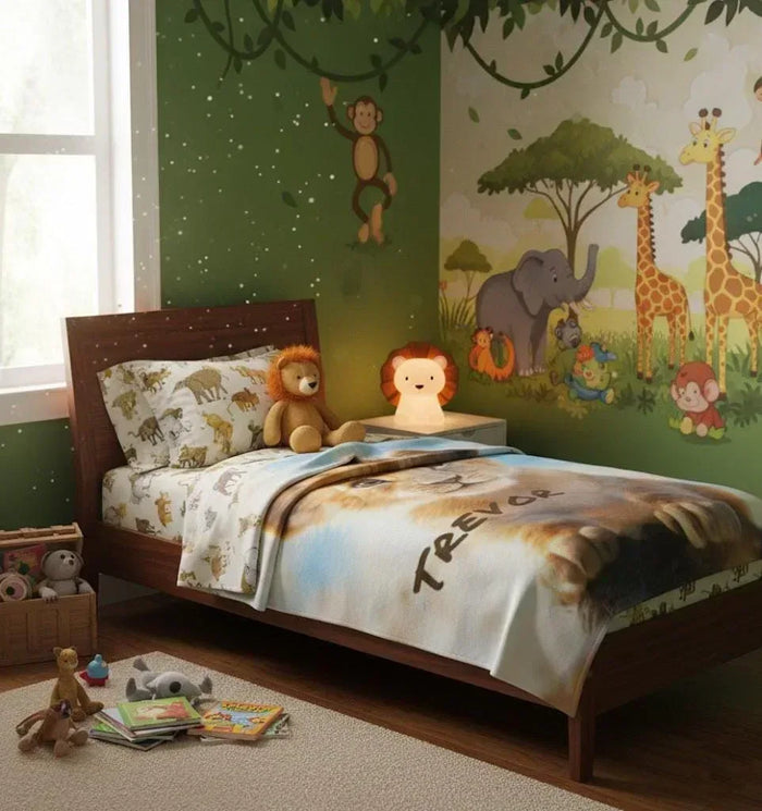 Personalized lion cub baby blanket on bed, name Trevor printed across the fabric